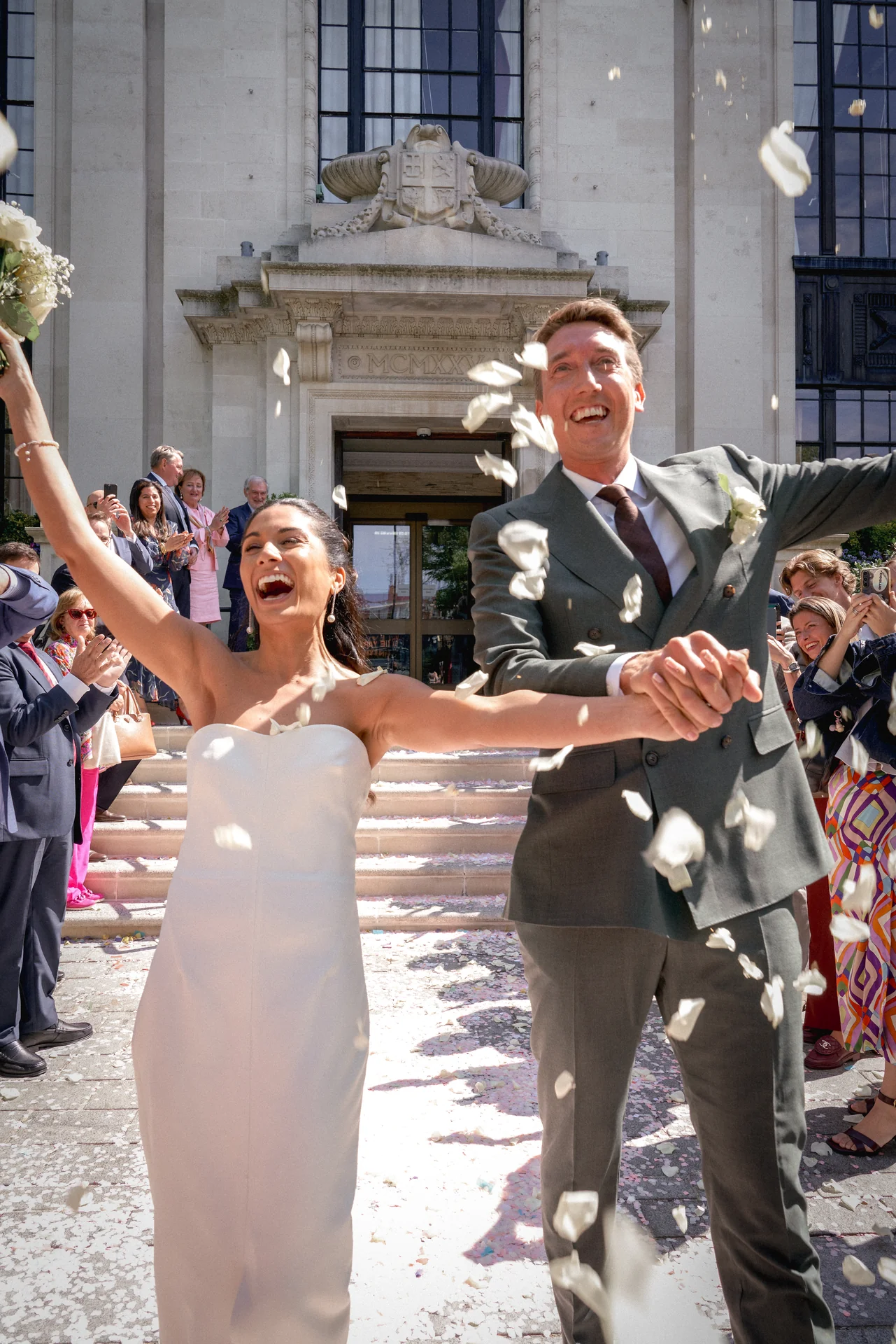 A bride and groom leaving through confetti