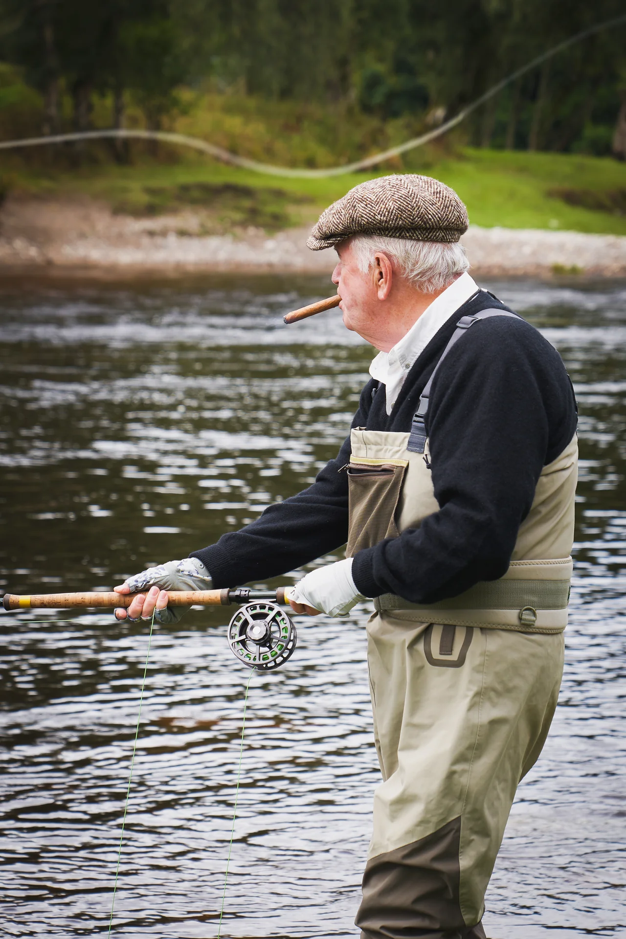A fly fisher in waders working a pool on the river