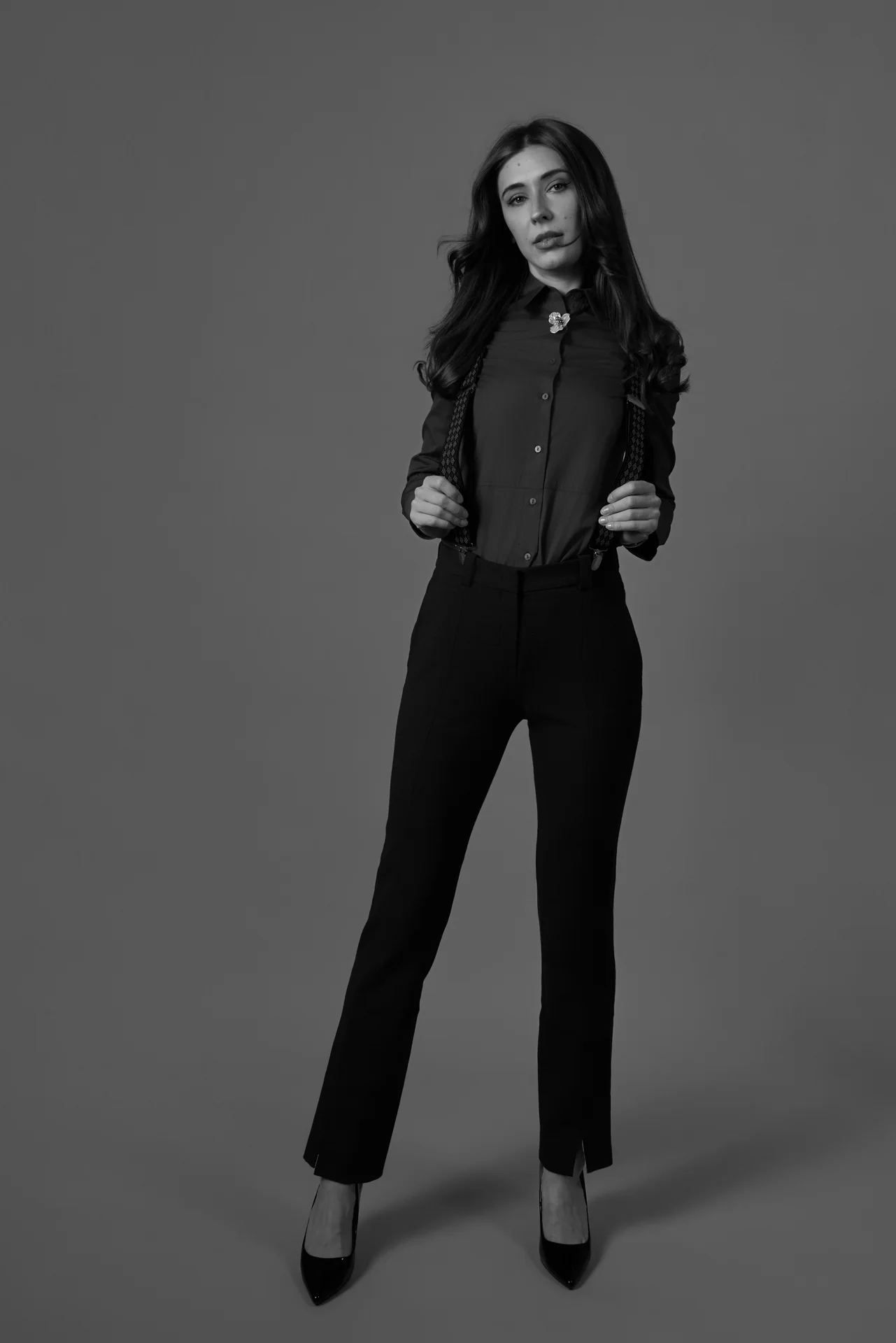 Black and white full length studio portrait of a woman in a suit