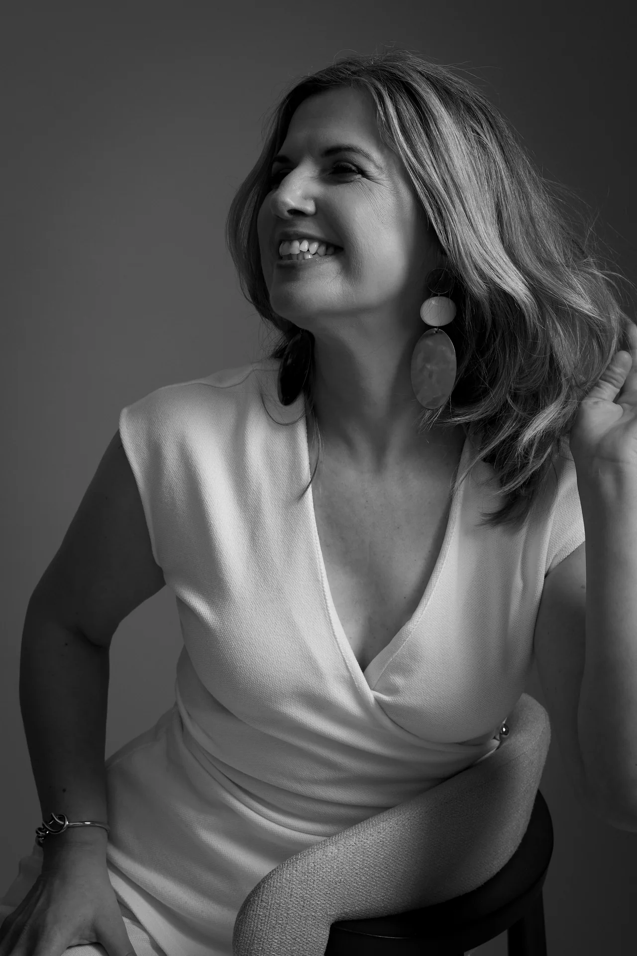 Black and white studio portrait of a woman laughing
